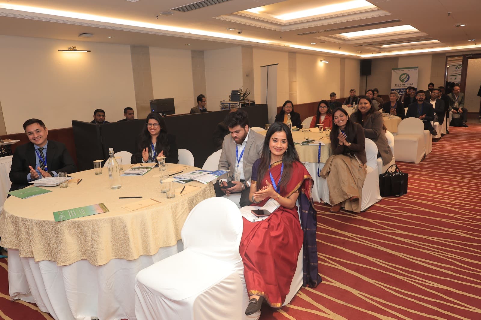 Delegates seated at round tables during a plenary session at a previous edition, IHC New Delhi